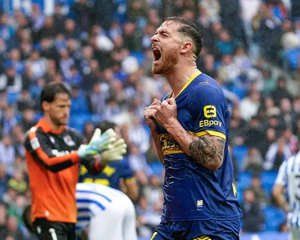 Jugador del Alavés celebra eufórico un gol contra la Real Sociedad. El portero observa con resignación.