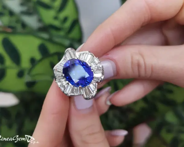 Anello con una preziosa pietra azzurra al centro, circondata da diamanti a baguette e taglio brillante.