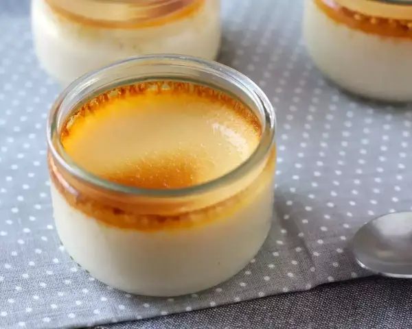 Trois pots de crème aux œufs caramel, avec une surface dorée et caramélisée. Un délice à déguster.