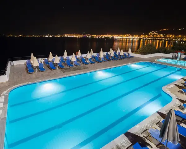 Basen hotelowy nocą, z widokiem na oświetlone miasto na horyzoncie. Idealne miejsce na relaks, jak sugerują pozytywne opinie o horizon beach.