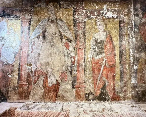 Fresque dégradée, exemple de l'art de la Renaissance, montrant des figures religieuses, dont une Vierge à l'Enfant et une sainte armée d'une épée.
