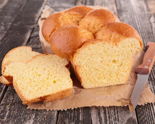 Brioche dorée, moelleuse et aérienne, parfaite pour une recette brioche machine à pain. Tranchée, elle révèle sa mie tendre.