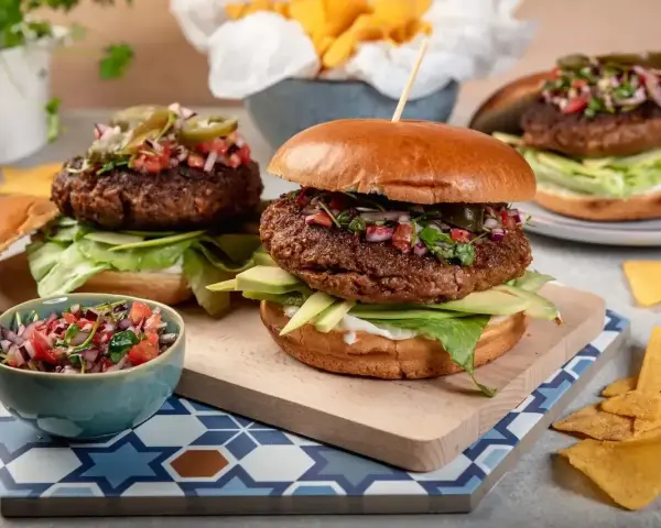Dwa soczyste burgery z awokado i salsą. Idealna sałata do burgera to ta chrupiąca, zielona, która dodaje świeżości.