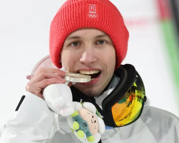 Kacper Tomasiak z medalem, który z dumą pokazują jego rodzice.