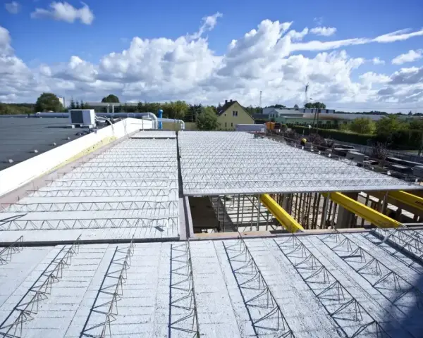 Budowa dachu z prefabrykowanych elementów, ukazująca różne rodzaje stropów w trakcie montażu.