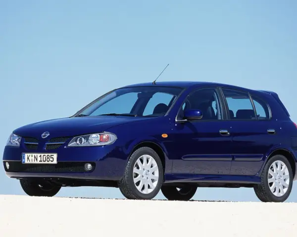 Granatowy Nissan Almera stoi na białym tle, z błękitnym niebem w tle.
