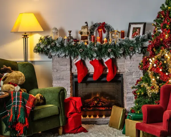 Acogedora sala con chimenea, árbol de Navidad y sillones. Una decoración navideña sostenible que invita a la calidez del hogar.