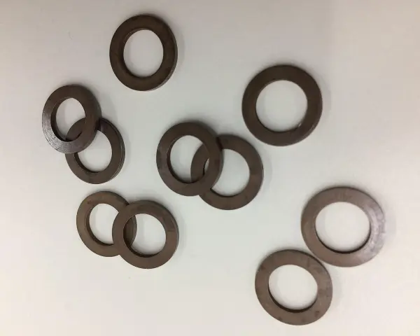 Un gruppo di rondelle alzaporta marroni, usate per regolare l'altezza delle porte.