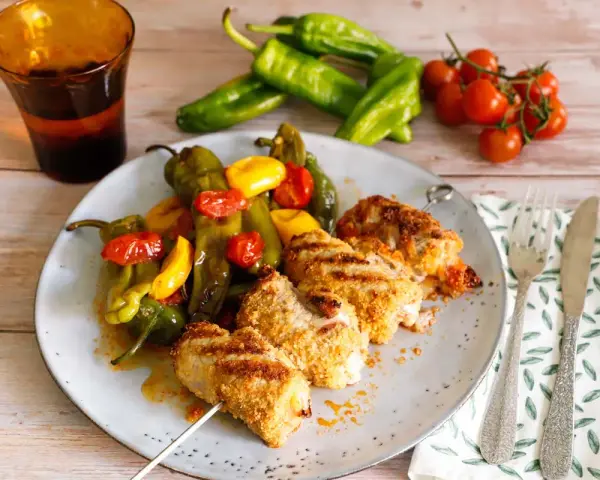 Spiedini di pollo impanato con friggitelli e pomodorini, un classico della ricetta pugliese.