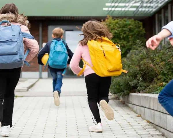 Niños corren con mochilas, ¡parece que ya empiezan las vacaciones de invierno!