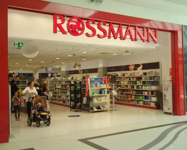 W Rossmannie, gdzie można zrobić wywołanie zdjęć z kliszy, matka z dziećmi robi zakupy.