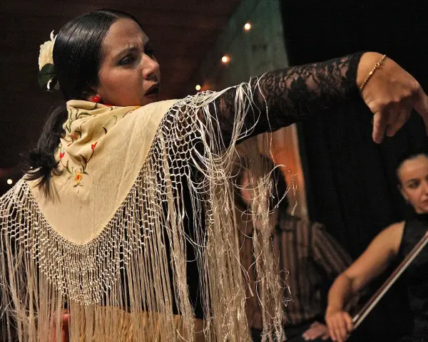 Tancerka flamenco z frędzlami na szalu, w tle skrzypaczka. To jest co to flamenco.