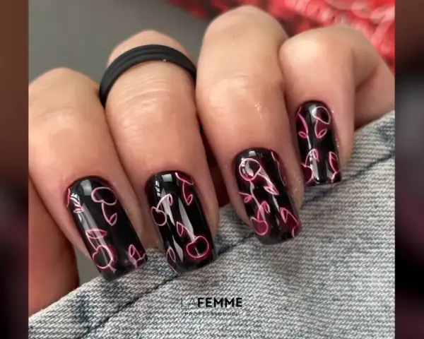 Unghie nere con un vivace disegno di ciliegie rosa neon. Un tocco di dolcezza estiva per le tue mani.