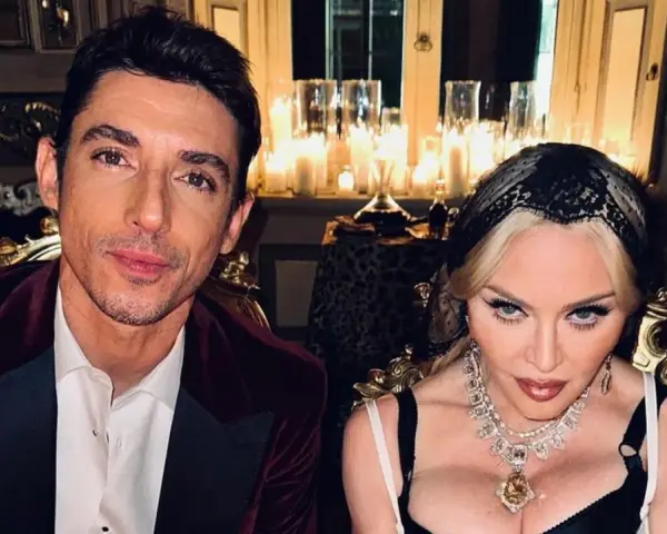 Un uomo con giacca di velluto bordeaux e Madonna con preziosi gioielli, in un'ambientazione suggestiva, forse per l'ultimo spot Dolce e Gabbana.