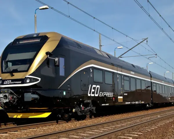 Nowoczesny, czarny pociąg LEO Express ze złotymi akcentami na torach.
