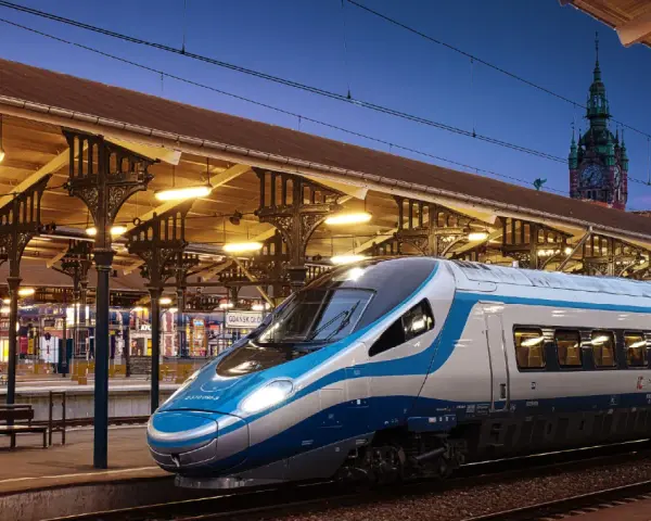 Pendolino Kraków-Gdańsk na dworcu w Gdańsku. Nowoczesny pociąg Intercity czeka na pasażerów pod zabytkową wiatą.
