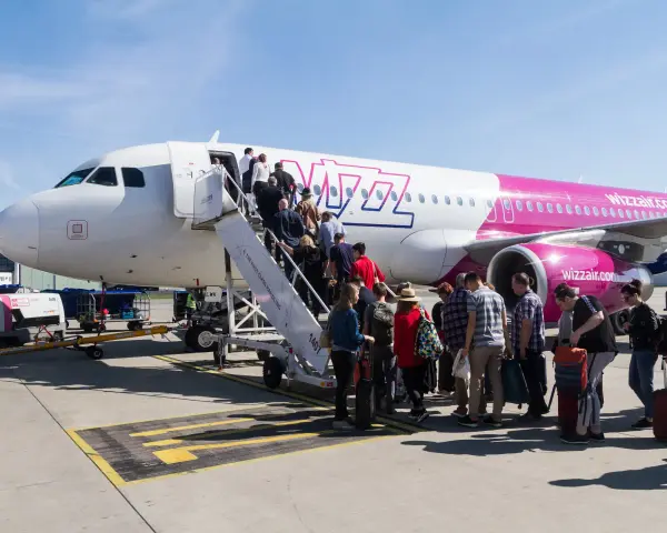 Pasażerowie Wizz Air wsiadają do samolotu. Zastanawiasz się, ile kosztuje bagaż Wizzair? Sprawdź cennik przed podróżą!
