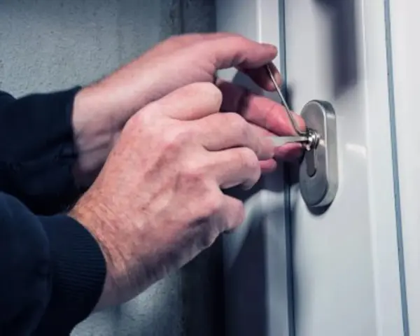 Mains expertes manipulant des outils pour tenter de comment ouvrir un portail sans clé.