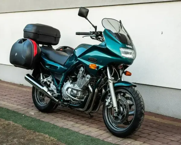 Zielony motocykl Yamaha XJ 900 z kuframi, gotowy na dalekie podróże.