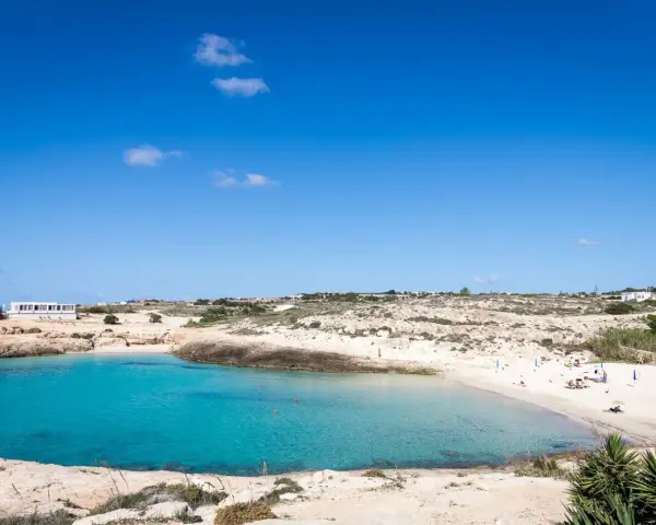 La **Cala Croce a Lampedusa** offre acque cristalline e una spiaggia dorata, ideale per rilassarsi sotto il sole.