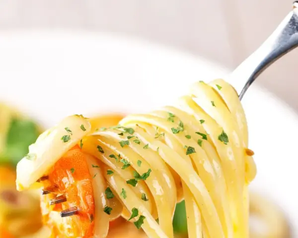 Un primo piatto invitante: spaghetti con gamberetti succulenti e prezzemolo fresco, pronti per essere gustati.