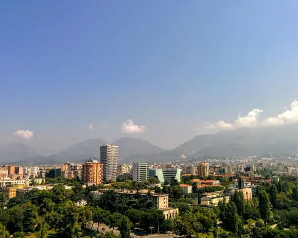 Widok na Tiranę, Albanię. Miasto z nowoczesnymi budynkami i górami w tle. Czy w Albanii jest bezpiecznie? Tak, podróżni często czują się tu bezpiecznie.