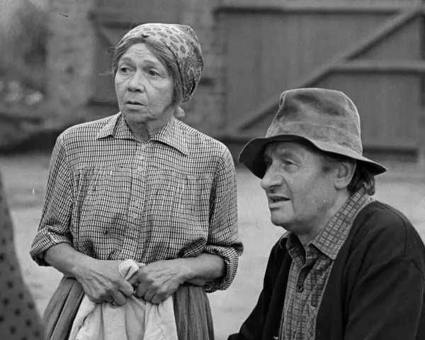 Marta Ławińska w stroju ludowym, obok mężczyzny w kapeluszu, w scenerii wiejskiej.