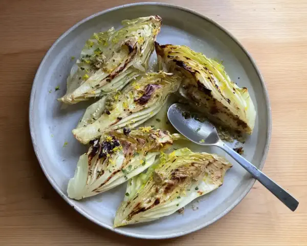 Ugnsbakad spetskål med citron och örter, serverad på en tallrik med en sked.