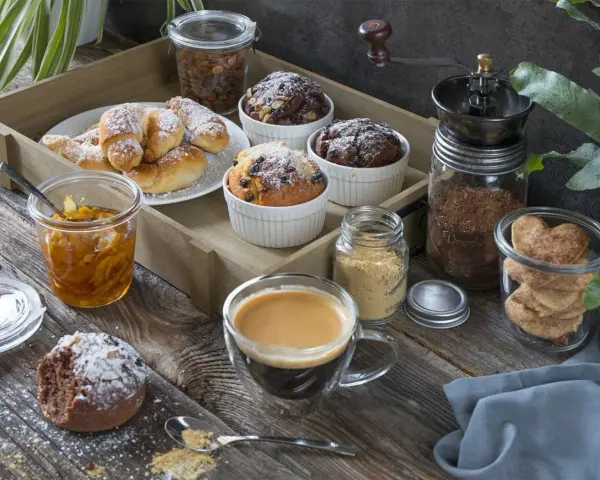 Idealny moment na fika w Szwecji: kawa, rogaliki, muffinki i ciasteczka w kształcie serc na drewnianej desce.