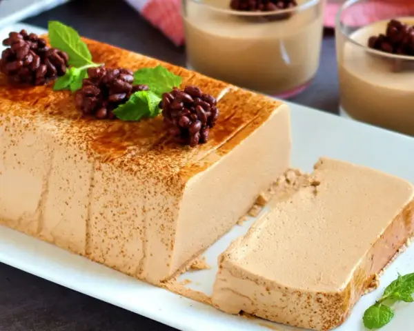 Deliciosa tarta de café, cremosa y con un toque de cacao espolvoreado. Perfecta para disfrutar en cualquier momento.