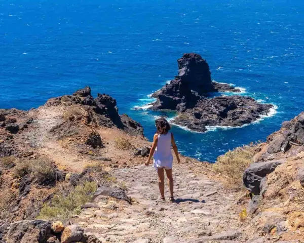 Sentiero roccioso verso il mare blu, un assaggio delle isole Canarie quali sono.