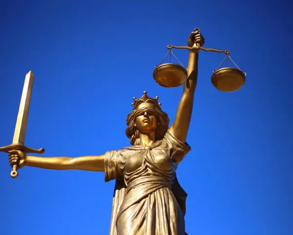Złota Temida z mieczem i wagą, symbol sprawiedliwości, jak europejski tytuł egzekucyjny.