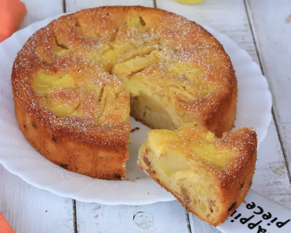 Una deliziosa torta di mele con crema pasticcera, cosparsa di zucchero a velo, pronta per essere gustata.
