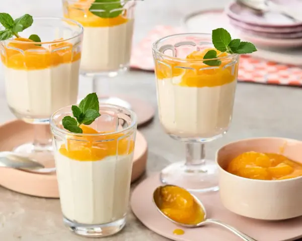 Leckeres Quarkspeise Rezept: Cremige Desserts mit Mandarinen und Minze in Gläsern serviert.