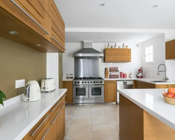 Cuisine moderne avec îlot central, électroménagers en inox et bois. Idéal pour estimer le prix rénovation maison m2.
