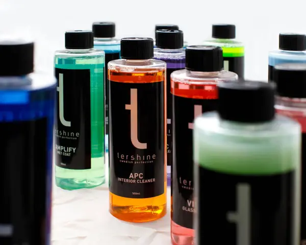 Flera flaskor med färgglada bilvårdsprodukter, inklusive en sprayflaska för kemikalier.