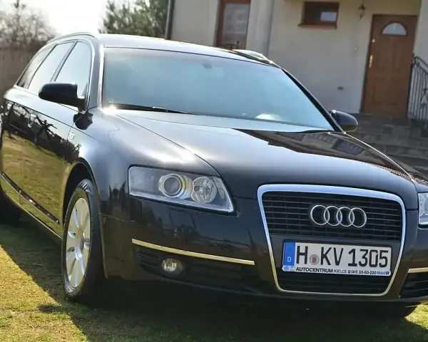 Czarny Audi A6 C6 3.0 TDI na trawie przed domem.