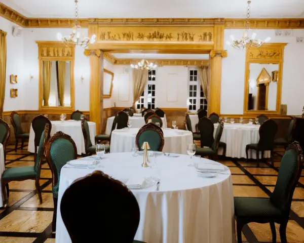 Elegancka sala bankietowa w lisewskim dworze, nakryte stoły czekają na gości.