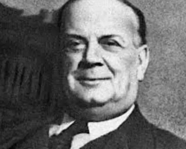Ritratto di Guccio Gucci, chi ha inventato Gucci, con un sorriso gentile.