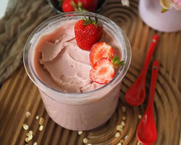 Cremiges Kefir Eis mit frischen Erdbeeren garniert, bereit zum Genießen.