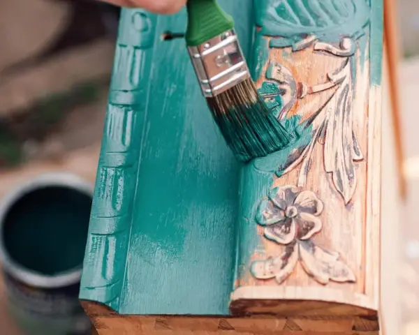 Pintura a la tiza verde turquesa cubriendo un marco de madera tallada.