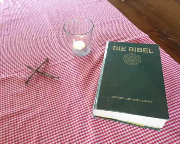 Ein Kreuz aus Zweigen, eine Kerze und die Bibel, die uns an Jesaja 43,19 erinnert: "Siehe, ich will ein Neues machen.