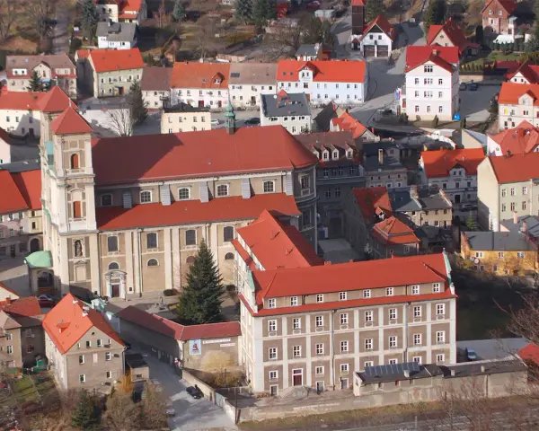 Widok z góry na miasteczko z czerwonymi dachami, w centrum imponujący kościół i zabudowania. To urokliwe bardo śląskie.