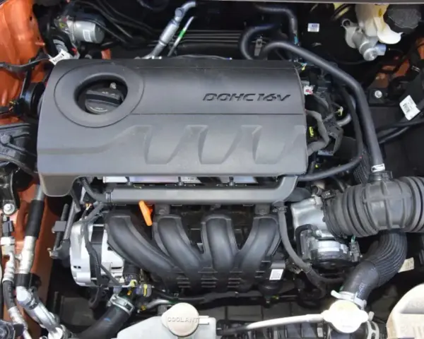 Silnik MPI DOHC 16V, widok z góry. Widać kolektor dolotowy, osłonę silnika i elementy układu dolotowego.