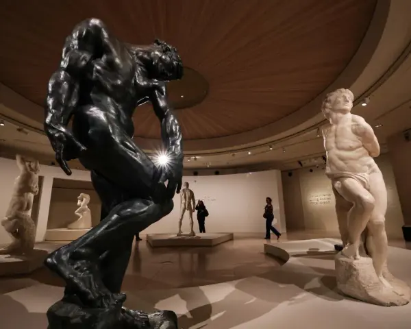 Musée d'art présentant des sculptures de sculpteurs célèbres, dont une grande statue en bronze et une statue en marbre.