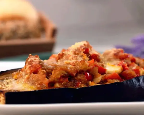 Berenjenas rellenas de atún, gratinadas con queso y trocitos de tomate. Un plato delicioso y fácil de preparar.