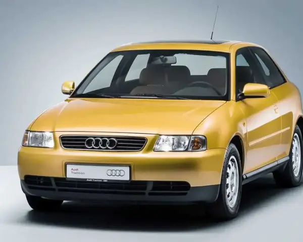 Gelber Audi A3 Baujahr 2000, dreitürig, mit Schiebedach und dem Schriftzug "Audi Tradition".