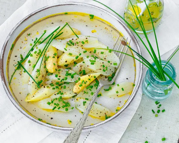 Spargel mal anders: zarte weiße Spargelstücke in einer cremigen Sauce, garniert mit Schnittlauch und Pfeffer. Ein leichter Genuss.