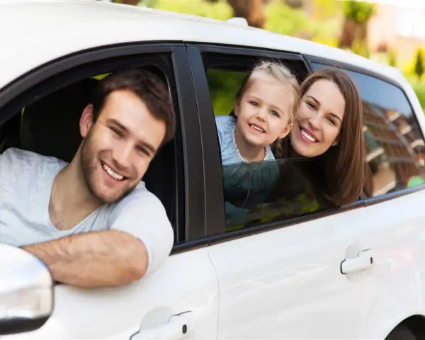 Famiglia felice in auto, un nuovo inizio dopo il passaggio di proprietà auto tra familiari.