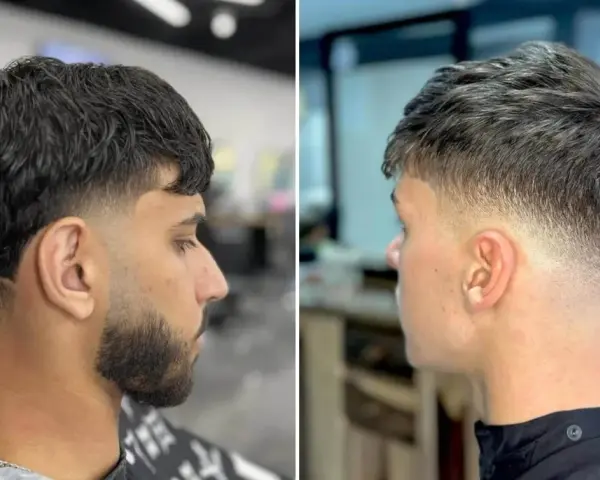 Zwei Männer mit stylischem taper cut. Der linke hat dunkles Haar und Bart, der rechte helleres Haar.